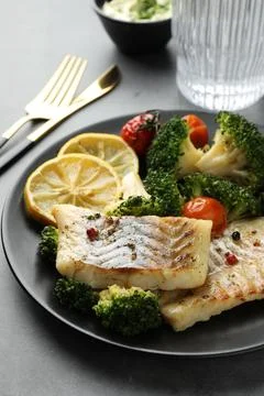 Tasty cod cooked with vegetables served on grey table, closeup Stock Photos