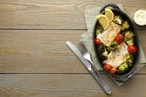 Tasty cod cooked with vegetables served on wooden table, flat lay. Space fo.. Stock Photos
