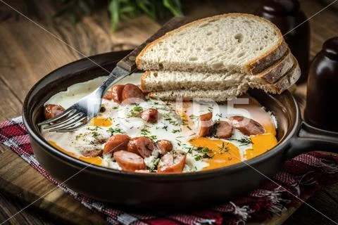 Tasty cooked egg with chopped sausages. Stock Photos