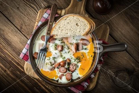 Tasty cooked egg with chopped sausages. Stock Photos