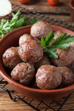 Tasty cooked meatballs with parsley on wooden table Stock Photos
