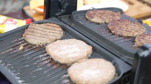 Tasty delicious burger patty flipped on hot seared grill pan Stock Footage