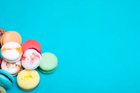 Tasty different colored macarons on blue background. Stockfoto's
