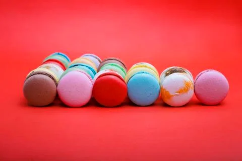 Tasty different colored macarons  on red background. Stock Photos