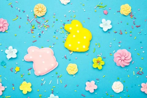 Tasty Easter cookies in shape on bunny and candies on blue background Stock Photos