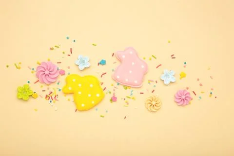 Tasty Easter cookies in shape on bunny and candies on beige background Stock Photos