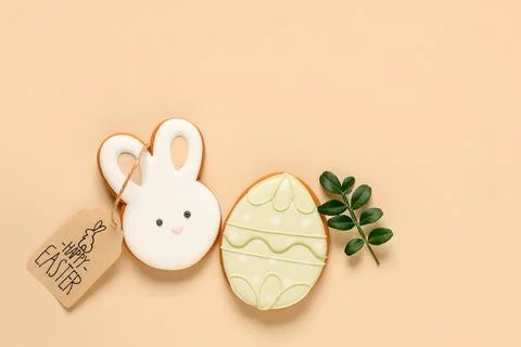Tasty Easter cookies in shape of bunny and egg on beige background Stock Photos
