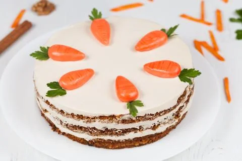 Tasty easter sponge cake with cream and little carrots on top Stock Photos