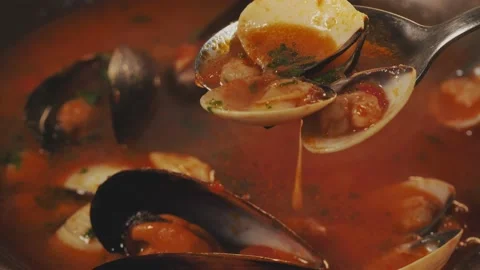Tasty fish soup boiling. Taking a spoonful of  Mediterranean fish soup with muss Stock Footage 235149607