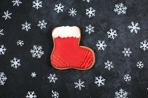 Tasty gingerbread cookie in shape of Boot and snowflakes on dark background. Stock Photos