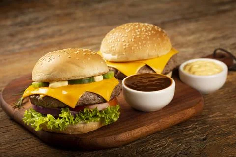 Tasty hamburger with sauces on wooden background. Stock Photos