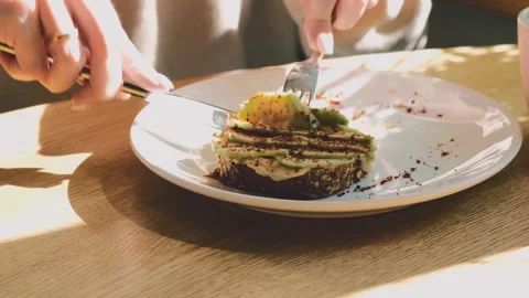 Tasty healthy breakfast concept. Close up of female hands slicing a delicious Stock Footage 160053355