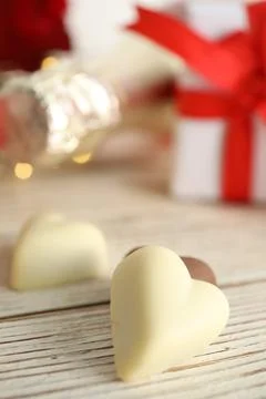 Tasty heart shaped chocolate candies on white wooden table, closeup. Valentin Stock Photos