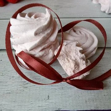 Tasty marshmallows tied with string on white wooden table Stock Photos