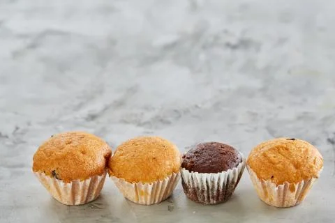 Tasty muffins arranged in pattern on light textured background, close-up Stock-Fotos