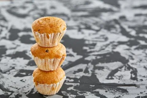 Tasty muffins arranged in pattern on light textured background, close-up Stock Photos