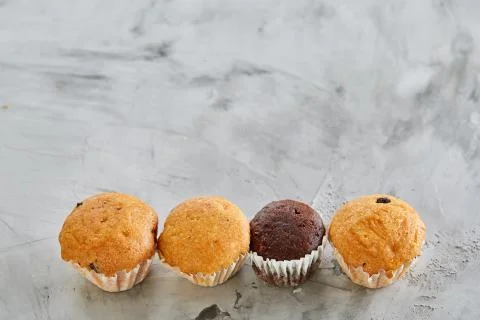 Tasty muffins arranged in pattern on light textured background, close-up Stock Photos
