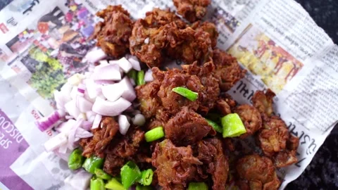 Tasty pakode with fried chilly and onion, served in Gujarati newspaper Indi.. 스톡 동영상 249754996