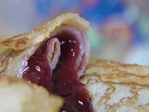 Tasty pancake rolls with topping, homemade strawberry jam – detail, closeup Stock Footage