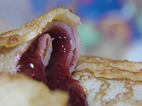 Tasty pancake rolls with topping, homemade strawberry jam – detail, closeup Stock Footage