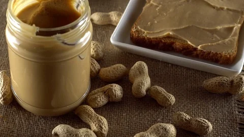Tasty peanut butter being spread on white toast Video stock 71338763