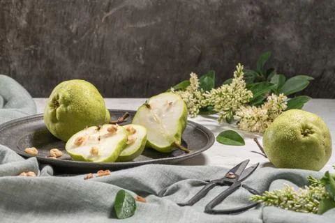 Tasty pears with nuts. A table decorated with flowers and a plate of pears cu Stock Photos
