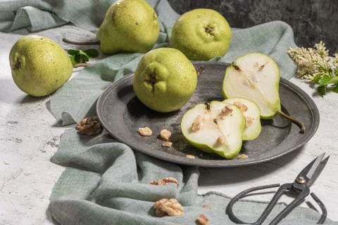 Tasty pears with nuts. A table decorated with flowers and a plate of pears cu Stock Photos