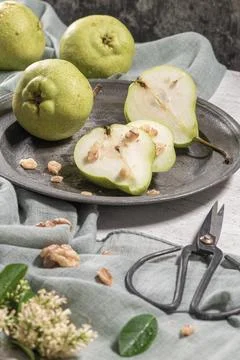Tasty pears with nuts. A table decorated with flowers and a plate of pears .. Foto stock