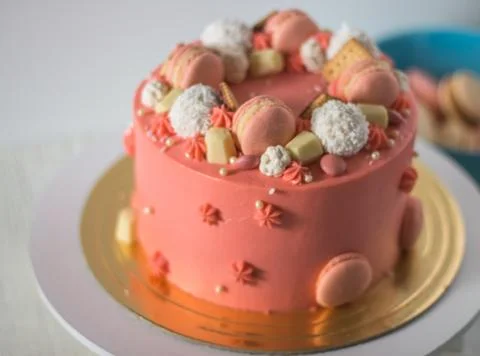 Tasty pink cake with macarons Stock Photos