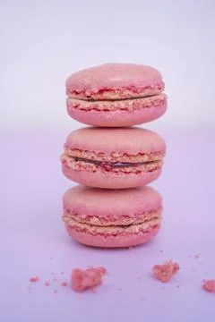 Tasty pink raspberry macarons on light violet background. French homemade des Stock Photos