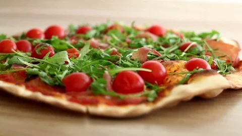 Tasty pizza with cherry tomato ham rucola , homemade prepared food Stock Footage