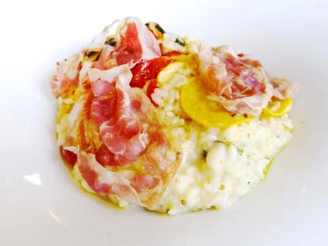 Tasty risotto with ham , fresh herbs vegetables on a white plate Stock Photos