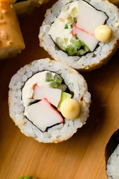 Tasty roll with Philadelphia cheese, crab stick, cucumber and avocado on wooden Stock Photos