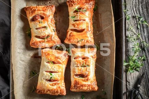 Tasty sausage in puff pastry with tatar sauce and herbs Stock Photos
