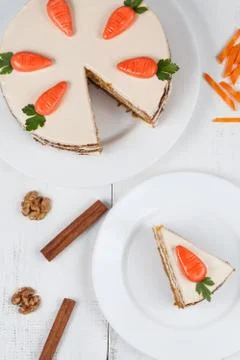 Tasty sliced easter carrot sponge cake with cream and little carrots on white Stock Photos