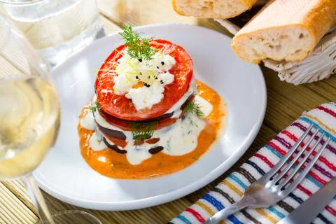 Tasty stack of fried eggplants and tomatoes on spicy sauce served at plate 스톡 사진