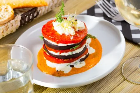 Tasty stack of fried eggplants and tomatoes on spicy sauce served at plate 스톡 사진