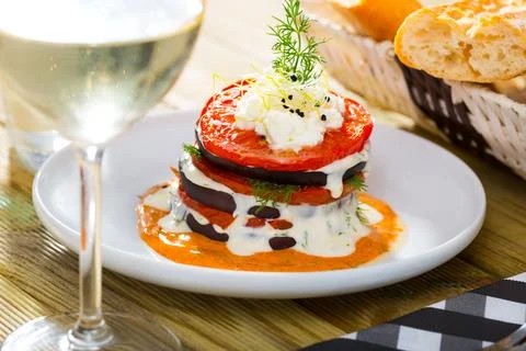 Tasty stack of fried eggplants and tomatoes on spicy sauce served at plate 스톡 사진