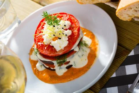 Tasty stack of fried eggplants and tomatoes on spicy sauce served at plate Foto stock