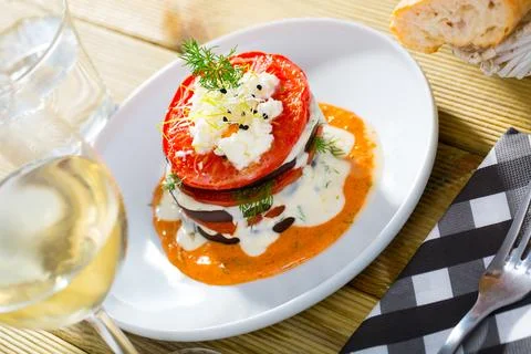 Tasty stack of fried eggplants and tomatoes on spicy sauce served at plate 스톡 사진