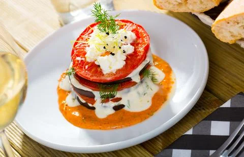 Tasty stack of fried eggplants and tomatoes on spicy sauce served at plate 스톡 사진