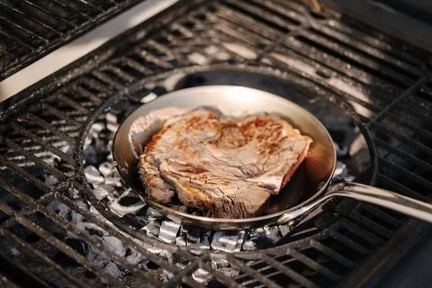 Tasty T-bone Steak on pan frying on BBQ grill. Close-up of beef steak. Grilled Stock-Fotos