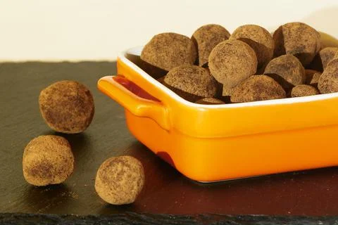 Tasty Truffles in ceramic square ramekin on black slate board Stock Photos
