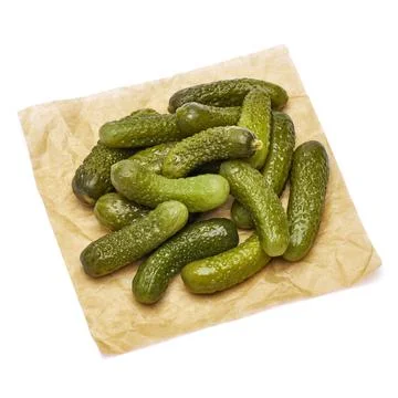 Tasty Whole green cornichons on parchment paper isolated on a white background Stock Photos