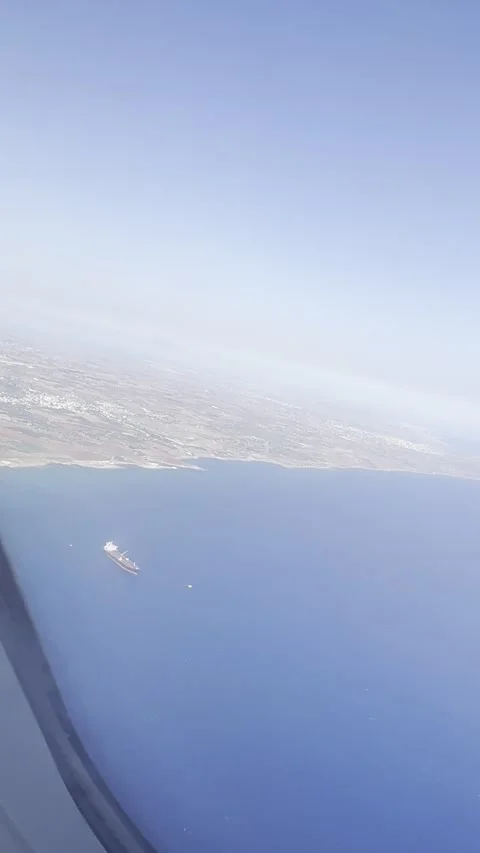 Tatic vertical shot of a coastline and blue sea from a flying airplane Stock Footage 336506637