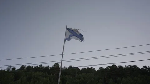 Tattered Russian Navy flag flutters prominently on background of serene evening Stock Footage 314489342