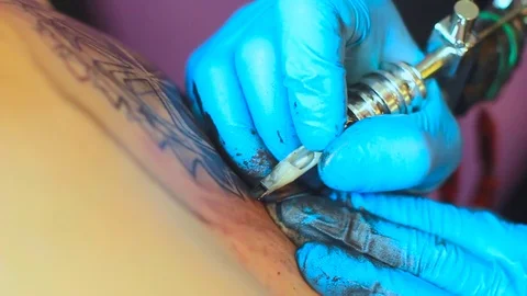 The tattoo artist does the tattoo Stock Footage 77376337