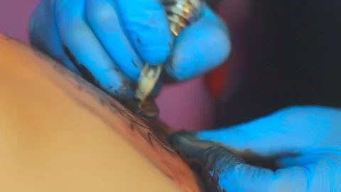 The tattoo artist does the tattoo Stock Footage 77376587