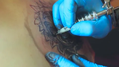 The tattoo artist does the tattoo Stock Footage 77376969