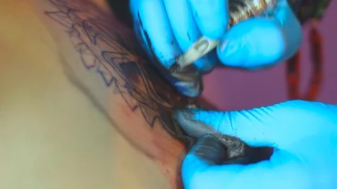 The tattoo artist does the tattoo Stock Footage 77383207